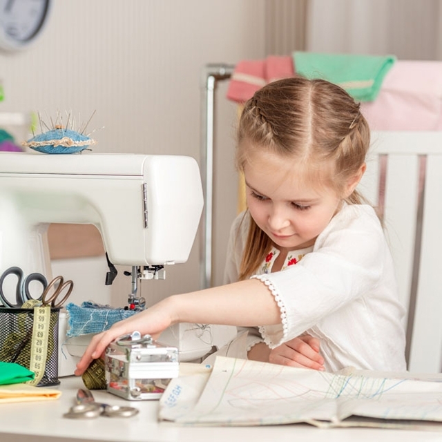 COUTURE_Photographie_640X640_Petite_fille_qui_travaille_à_la_machine_à_coudre
