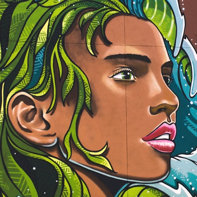 PEINTURE_MURALE_Photographie_640X640_cadrée_de_peinture_murale_extérieure_illustrant_une_jeune_fille_aux_cheveux_ondulants_verts_et_bleus