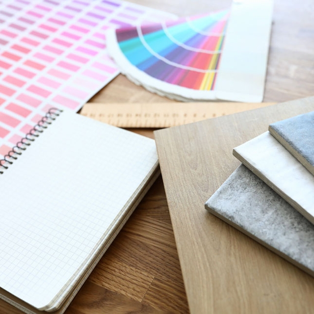 PROCESSUS_DÉCO_Photographie_640x640_Évaluation_des_éléments_décoratifs–Échantillons_de_matériaux_règle_charte_de_couleurs_et_cahier_de_notes_posés_sur_une_table