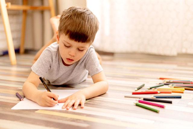 CHAMBRES_ENFANTS_Photo_640X427_Garçon_allongé_sur_le_plancher_de_sa_chambre_pour_faire_du_dessin CHAMBRES_ENFANTS_Photo_640X427-Jeune_garçon_allongé_de_manière_décontractée_sur_le_plancher_de_sa_chambre_avec_ses_crayons_de_couleurs_pour_faire_du_dessin